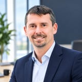 Nicolas PIERRAT, fondateur de NPC, souriant, en veste bleu marine